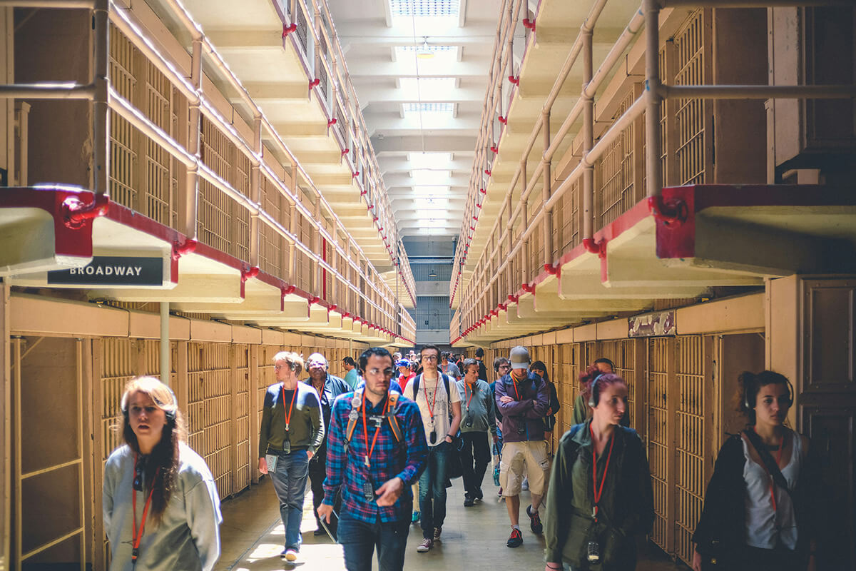 Guests taking an Alcatraz tour with audio guide inside the cellhouse