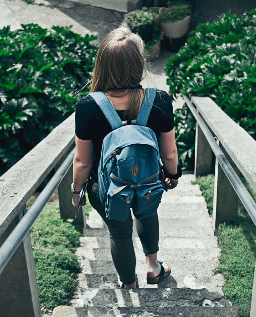 Woman with backpack hiking down stairs